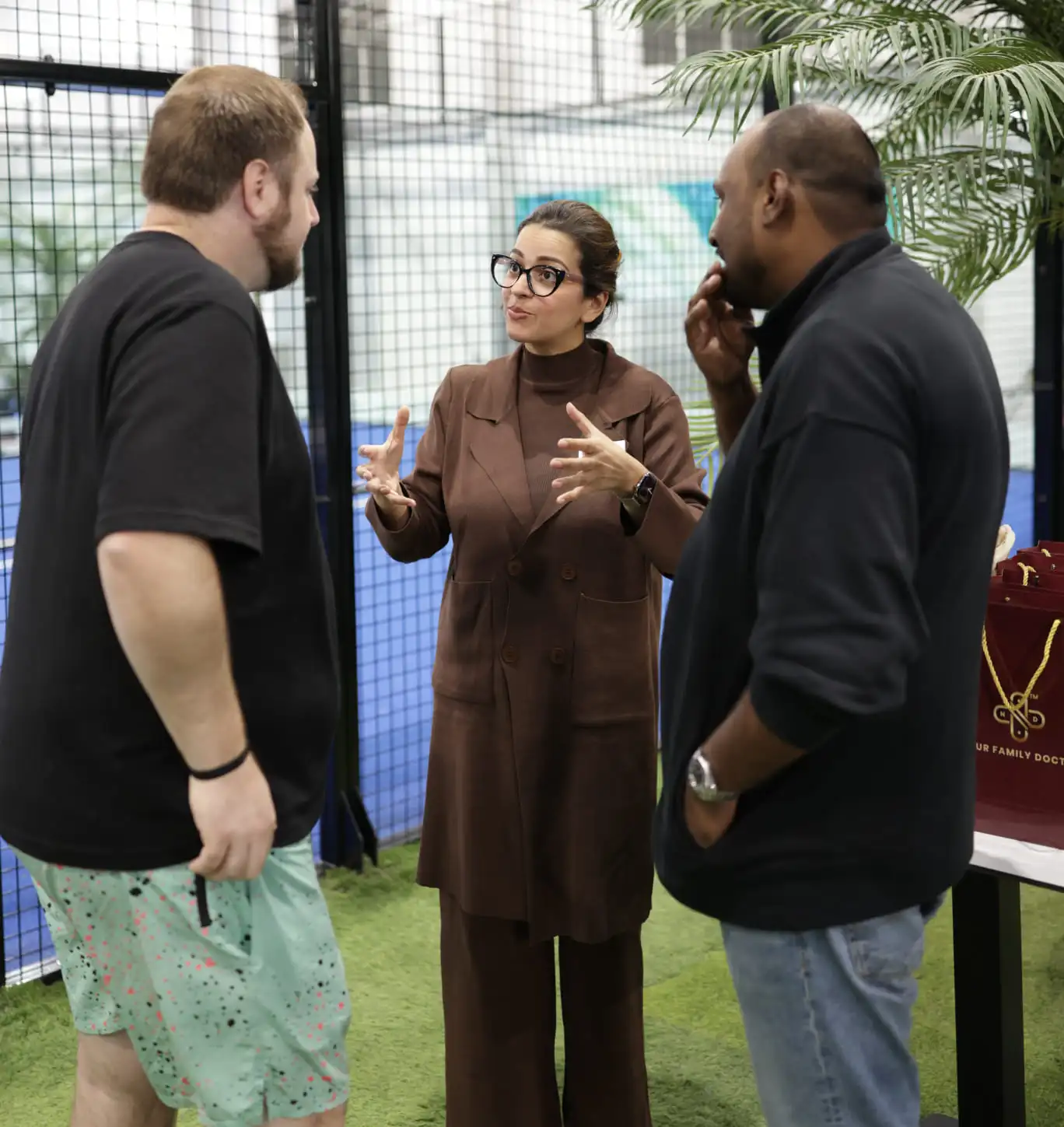 Dr. Nadia Choudhry speaking with guests at a padel club event